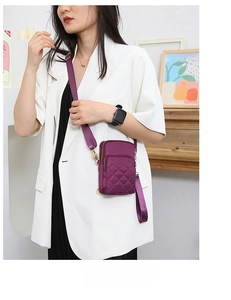 Quilted purple nylon cell phone crossbody bag with adjustable wide strap on model