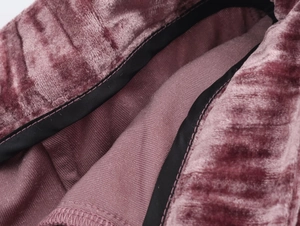 Detail of velvet suit fabric texture with black piping and reinforced stitching