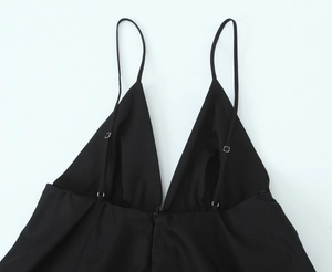 Close-up of black sleeveless mini dress with adjustable thin straps and deep V-neckline
