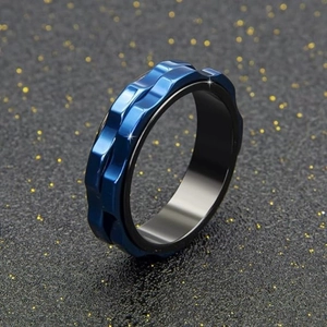 Detail of blue titanium steel rotating gear ring with wavy texture on black background