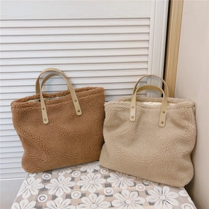 Detail view of coffee and beige plush lamb wool tote bags with smooth handles and rivets