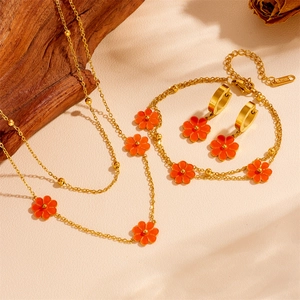 Golden stainless steel jewelry set featuring orange daisies with necklace, bracelet and earrings