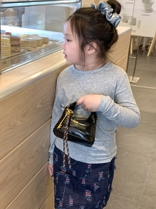 Black mini crossbody lunchbox bag with gold hardware and woven rope detail