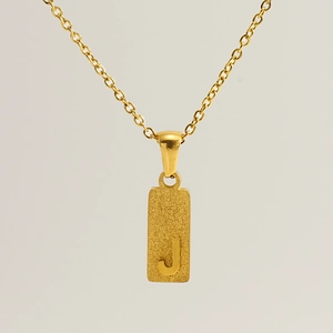 Close-up of gold stainless steel necklace featuring a rectangular Letter J pendant