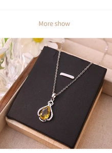 Detail of yellow waterdrop zircon perfume bottle pendant necklace on black leather stand