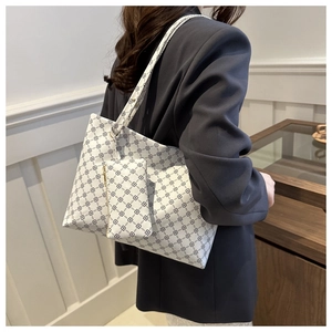 Close-up of white tote bag with chain pattern and matching small pouch charm