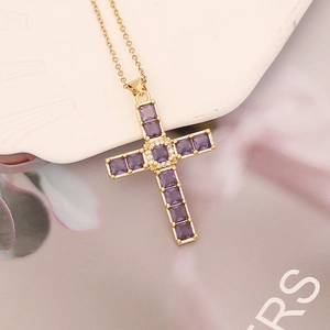 Detail of gold cross pendant with purple square stones and white zircon micro-inlay