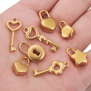 Set of 8 mini golden stainless steel lock and key charms in hand for size reference