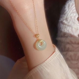 Elegant gold titanium steel necklace with a green jade peace buckle and hollow charm