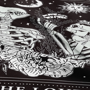 Detail of tarot skull tapestry showing fine sun and moon print on black woven fabric
