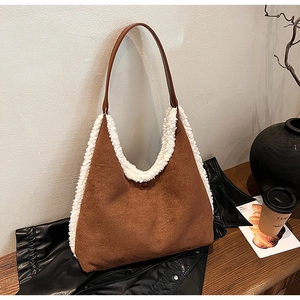 Brown suede tote bag with white plush trim detail shown in a cozy lifestyle setting