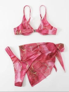 Detailed flat lay of three-piece marble print bikini set with pink and gold accents