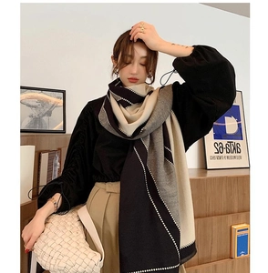 Detailed shot of double-sided cashmere scarf featuring elegant pearl trim and color block design