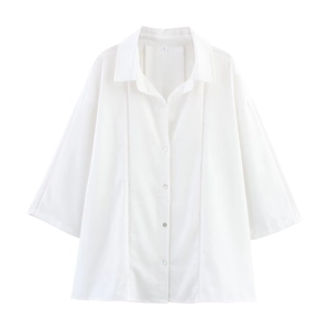 Detail of white linen shirt showing lace trim, buttons, and breathable fabric texture