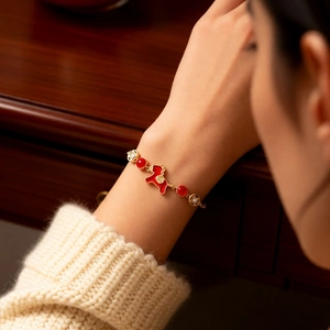 Détail d'un bracelet cheval plaqué or avec des perles d'agate rouge et des accents de diamant