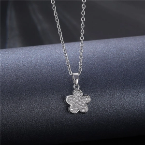 Elegant silver flower pendant necklace with micro-paved zircons on a gray background