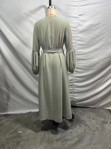 Vue arrière d'une robe en mousseline vert clair à pois texturés et ceinture à boucle