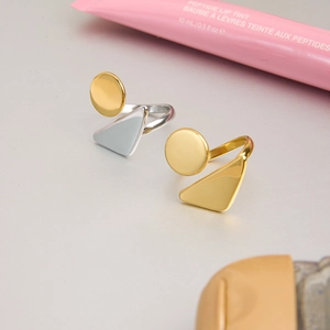 Macro view of geometric gold and silver stainless steel rings with a smooth metallic finish