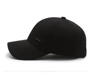 Detail of black cotton baseball cap with a metal Sport badge and twill texture finish