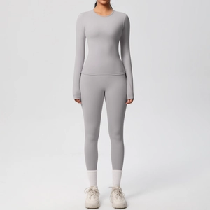 Vista frontale di un set da yoga grigio con maniche lunghe e leggings in tessuto elastico