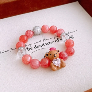 Détail d'un bracelet en perles avec pendentif ours en zircon dans un écrin à bijoux