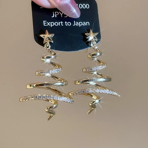 Detailed macro view of gold-plated Christmas tree drop earrings with sparkling cubic zirconia
