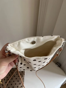 Detailed view of beige polka dot corduroy bag with magnetic closure and inner lining