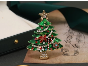Macro shot of green enamel Christmas tree brooch with colorful rhinestones and gold plating