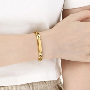 Detailed view of a gold curved bar bracelet on a wrist featuring a minimalist metal chain
