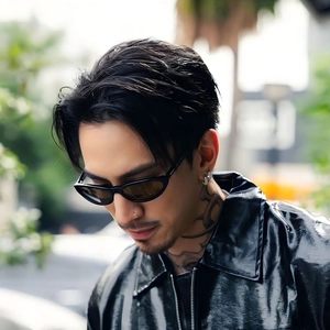 Close-up of black cat-eye sunglasses on model wearing a glossy leather jacket