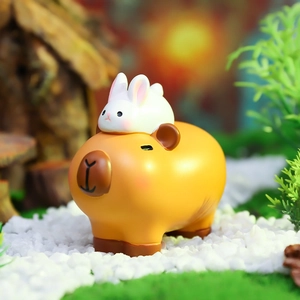 Macro shot of resin Capybara figure with white rabbit on back for car dashboard decor