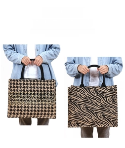 Detail of jute tote bags featuring houndstooth and zebra patterns with tubular handles