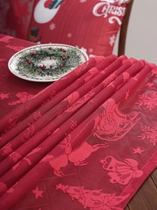 Close-up of red Christmas lace tablecloth featuring reindeer and snowflake patterns