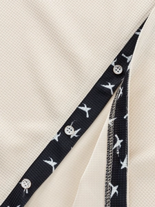 Macro view of waffle knit fabric and bird print placket on men's casual shirt