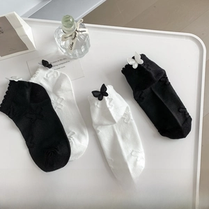 Detail of JK Lolita cotton socks with elegant bows and jacquard texture in black and white