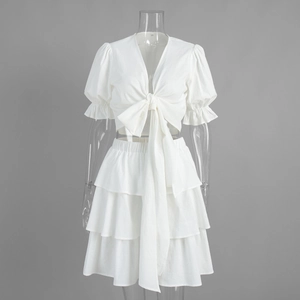 Front detail of white 2-piece set with puff sleeve tie-up top and tiered cake skirt