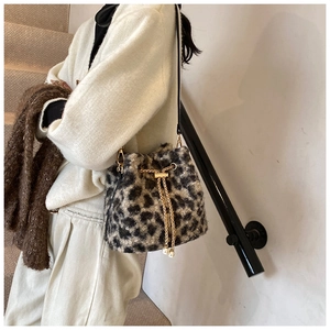 Detail view of leopard print plush bucket bag with golden chain and pearl charms