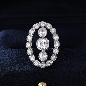 Macro detail of luxury silver ring with triple oval zircon stones on blue velvet