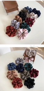 Close-up of assorted ribbed knit scrunchies in vintage tones on a minimal desk