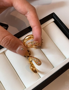 Close-up of gold-plated cross open ring with colorful zircon stones and brand engraving