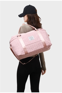 Quilted pink travel bag detail showing large capacity, handles and shoulder strap