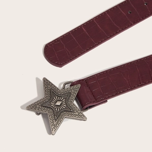 Detail eines burgunderroten Gürtels mit Krokoprägung und Vintage-Silber-Sternschnalle