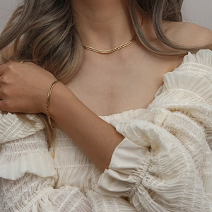 Chic gold-plated Cuban chain necklace and bracelet set worn on a female model