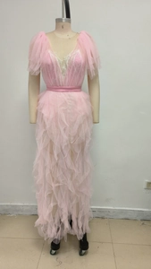 Detail of pink ruffled mesh dress featuring deep V-neckline and delicate lace trim