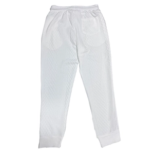Close-up of white knit joggers with textured diamond pattern and elastic waistband