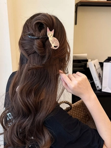 Vue détaillée d'une pince à cheveux chat rose dégradé avec strass sur cheveux bouclés