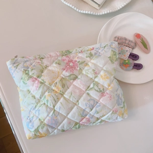 Close-up of floral quilted cotton makeup bag with elegant vintage flower pattern and zipper