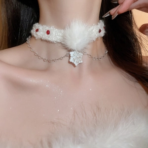 Détail du ras-du-cou en fourrure blanche avec strass rouges et pendentif fleur en perle