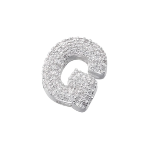 Macro shot of silver letter G pendant with micro-paved cubic zirconia and metallic luster