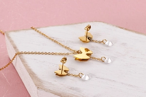 Nahaufnahme von goldenem Schmetterlingsschmuck-Set mit Zirkon auf weißem Holzblock